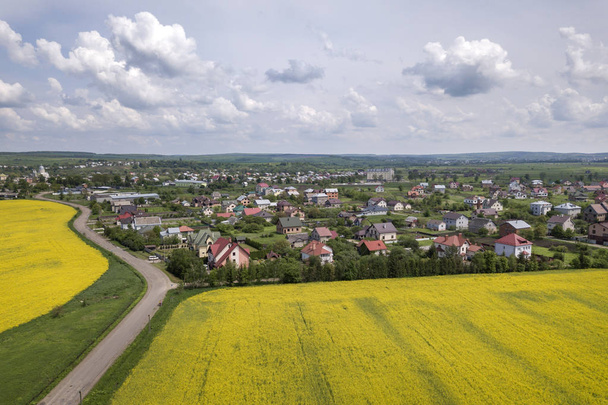Аерофотозйомка наземної дороги в зелених полях з квітучими ріпаками
 - Фото, зображення