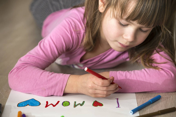 Cute child girl drawing with colorful crayons I love Mom on whit - Zdjęcie, obraz