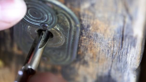 Schlüssel in Schlüsselloch gesteckt und von männlicher Hand gedreht - Filmmaterial, Video