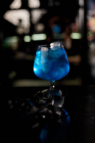 primo piano di cocktail blu ghiaccio sul bancone del bar in legno
 - Foto, immagini