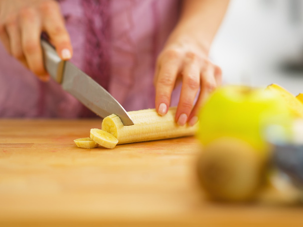 Closeup on woman cutting banana on cutting board - Φωτογραφία, εικόνα