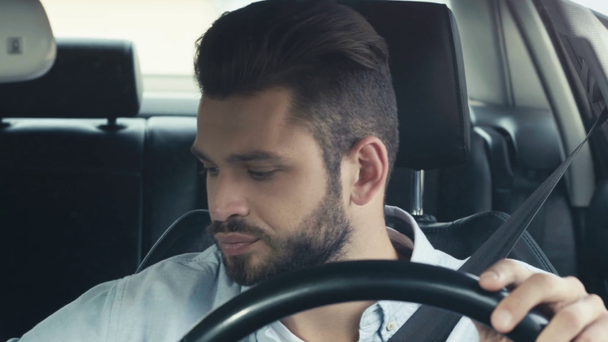 duygusal sakallı adam saat bakarak seçici odak, akıllı telefon alarak ve arabada otururken saat bakarak  - Video, Çekim
