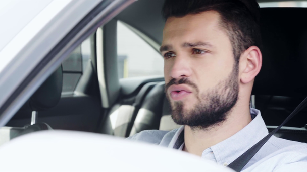 enfoque selectivo del hombre guapo cantando mientras está sentado en el coche
  - Imágenes, Vídeo