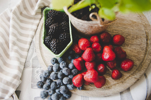 fresh strawberry blueberry and blackberry on wooden desk - Foto, Bild