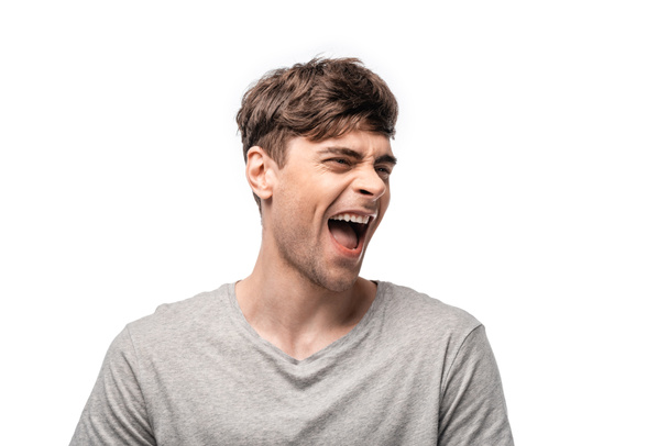 excited young man laughing while looking away isolated on white - Foto, Imagem