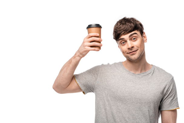 cheerful young man holding disposable cup and smiling at camera isolated on white - Photo, Image