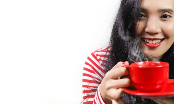 sorridente donna asiatica in possesso di tazza rossa di bevanda
 - Foto, immagini