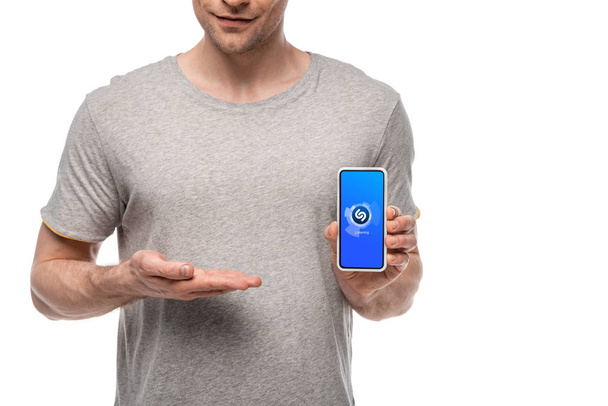 KYIV, UKRAINE - MAY 16, 2019: cropped view of man presenting smartphone with shazam app, isolated on white - Photo, image