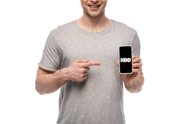 KYIV, UKRAINE - MAY 16, 2019: cropped view of smiling man pointing at smartphone with HBO app, isolated on white - Photo, image