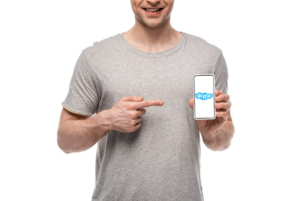 Kijów, Ukraina-16 maja 2019: przycięte widok uśmiechnięty człowiek wskazując na smartphone z aplikacją Skype, izolowane na białym - Zdjęcie, obraz