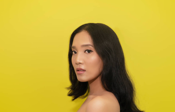 sarı arka plan üzerinde parlak deri ile genç Asyalı kadın portresi - Fotoğraf, Görsel