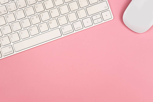 Pink office desk background with computer keyboard and other office supplies. Top view with copy space, flat lay. - Фото, зображення