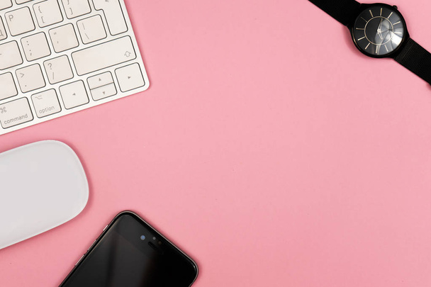 Pink office desk background with computer keyboard and other office supplies. Top view with copy space, flat lay. - Фото, изображение