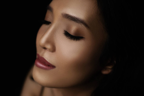 portrait of young asian woman with glossy skin on dark background - Zdjęcie, obraz