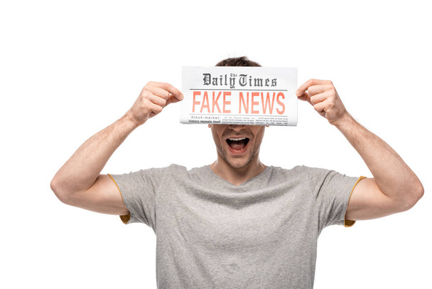 młody człowiek pokazując gazetę z fałszywymi wiadomościami na białym tle - Zdjęcie, obraz