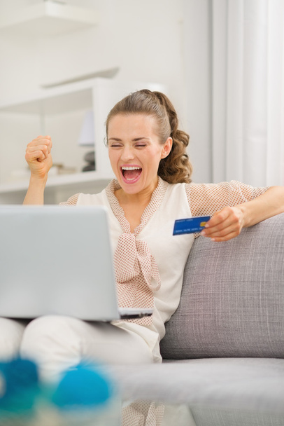 Happy young housewife with laptop and credit card - Fotó, kép