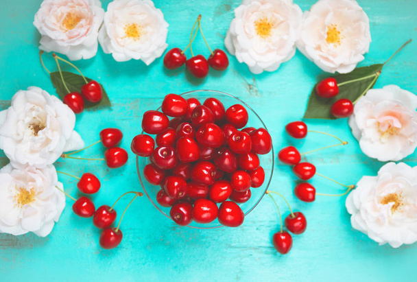 Fresh red cherry in a bowl on an old painted wooden table with f - Foto, Bild