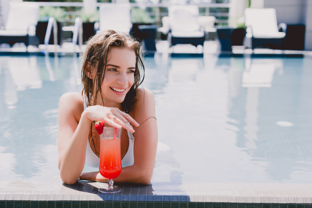 femme humide blonde heureuse dans la piscine avec cocktail fraise fraîche
 - Photo, image