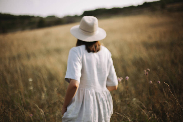Imagen borrosa de niña en vestido de lino corriendo entre hierbas y wil
 - Foto, Imagen