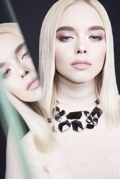 Beautiful young blonde with classic makeup and modern jewelry - 写真・画像