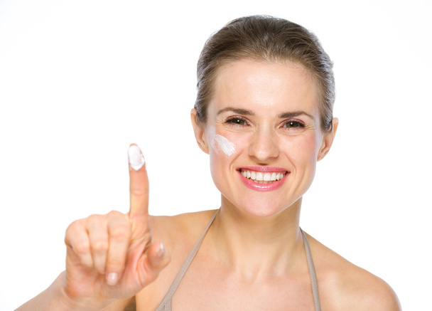 Beauty portrait of happy young woman showing creme on finger - Photo, Image
