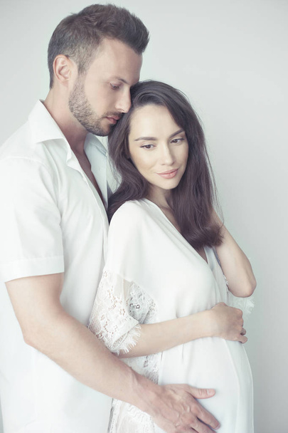 Handsome man hugging his pregnant wife - Foto, afbeelding