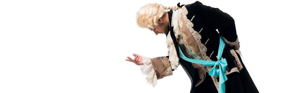 panoramic shot of handsome victorian gentleman in wig gesturing while bowing down isolated on white  - Photo, Image