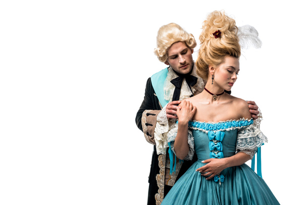 handsome man in wig touching attractive victorian woman in blue dress isolated on white  - 写真・画像