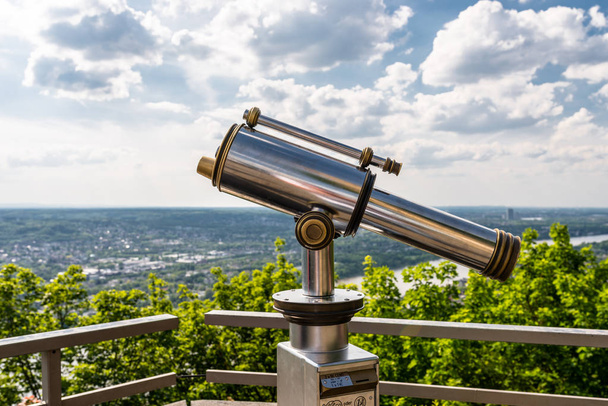 Betaalde enkele lens telescoop, gelegen op een hoog uitkijkpunt met uitzicht op de stad. - Foto, afbeelding