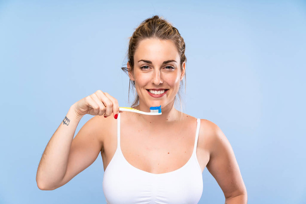 彼女の歯を磨く幸せな若いブロンドの女性 - 写真・画像