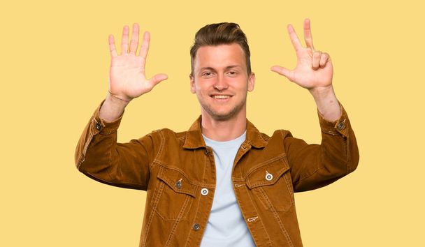 Blonde handsome man counting eight with fingers - Photo, Image