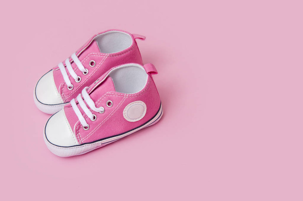 Schattig roze baby meisje sneakers close-up op roze achtergrond - Foto, afbeelding