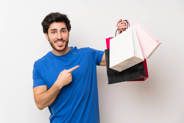 Bonito homem segurando um monte de sacos de compras
 - Foto, Imagem