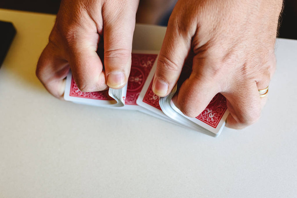 Hands of magician shuffling a deck of poker cards before doing a - 写真・画像