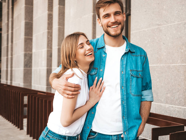 Portrait of smiling beautiful girl and her handsome boyfriend. Woman in casual summer jeans clothes. Happy cheerful family. Female having fun on the street background - Fotó, kép