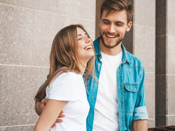 Portrait of smiling beautiful girl and her handsome boyfriend. Woman in casual summer jeans clothes. Happy cheerful family. Female having fun on the street background - Foto, afbeelding