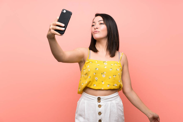 junge Mexikanerin macht Selfie über Mauer - Foto, Bild