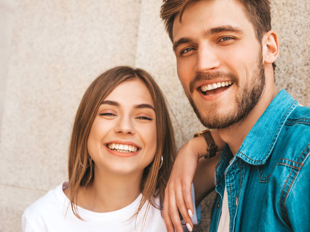 Smiling beautiful girl and her handsome boyfriend in casual summer clothes. Happy family taking selfie self portrait of themselves on smartphone camera. Having fun on the street background  - Fotoğraf, Görsel