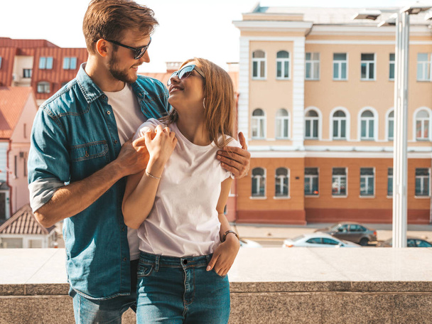 Portrait of smiling beautiful girl and her handsome boyfriend. Woman in casual summer jeans clothes. Happy cheerful family. Female having fun on the street background in sunglasses - Zdjęcie, obraz