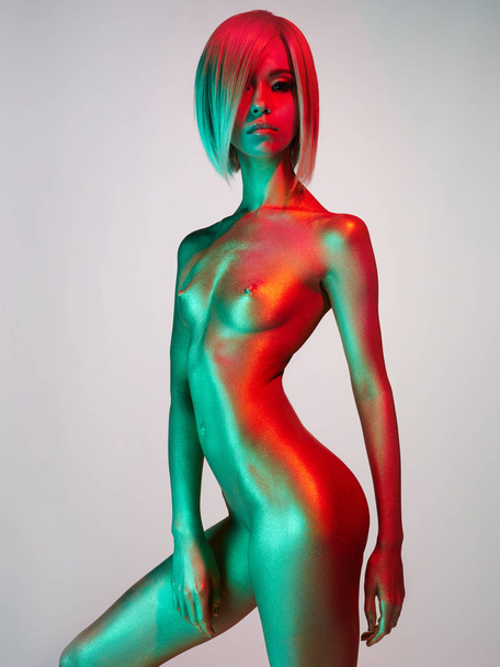 Elegant nude model in the light colored spotlights - Foto, Imagem