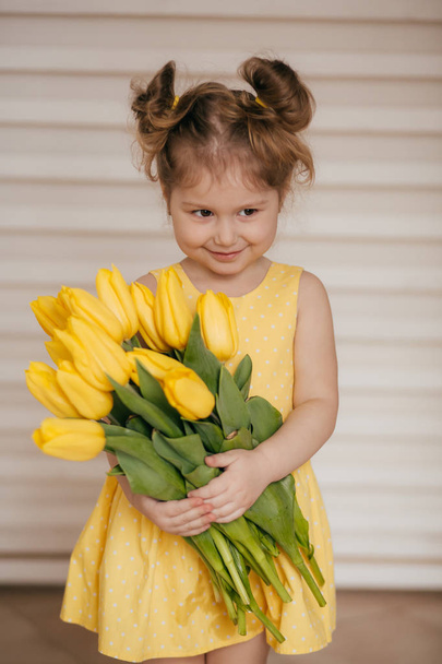 Portrait de belle petite fille aux fleurs jaunes
  - Photo, image