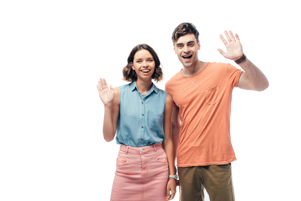 young, cheerful man and woman waving hands while smiling at camera isolated on white - Фото, изображение