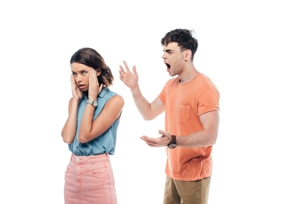 irritated young man gesturing while quarreling at offended girlfriend isolated on white - Foto, Imagen
