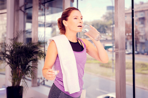 Tired brunette woman refreshing herself with water - Zdjęcie, obraz