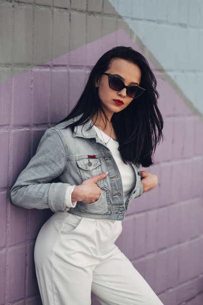 Beautiful Brunette Girl in Sunglasses White Pants and Jeans Jacket, Red Lipstick - Zdjęcie, obraz