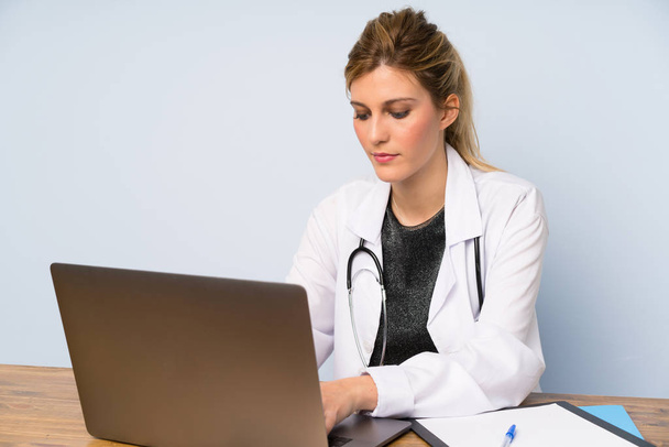 Szőke orvos nő vele laptop - Fotó, kép