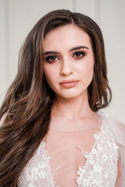 Gorgeous brunette bride in luxury white lingerie. Makeup Details. Thick and long eyelashes. Nude Lipstick on Plump Lips. Closeup portrait girl. perfect makeup for the bride - Image - Zdjęcie, obraz