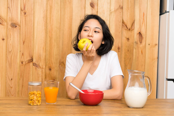 Asiática joven mujer desayunando y con una manzana
 - Foto, imagen