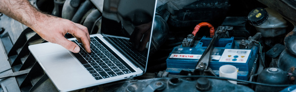 panoramic shot of car mechanic using laptop with blank screen near car  - Photo, Image