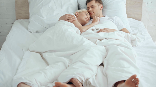 pareja tocando las piernas, abrazando y besando mientras está acostado en la cama
 - Imágenes, Vídeo